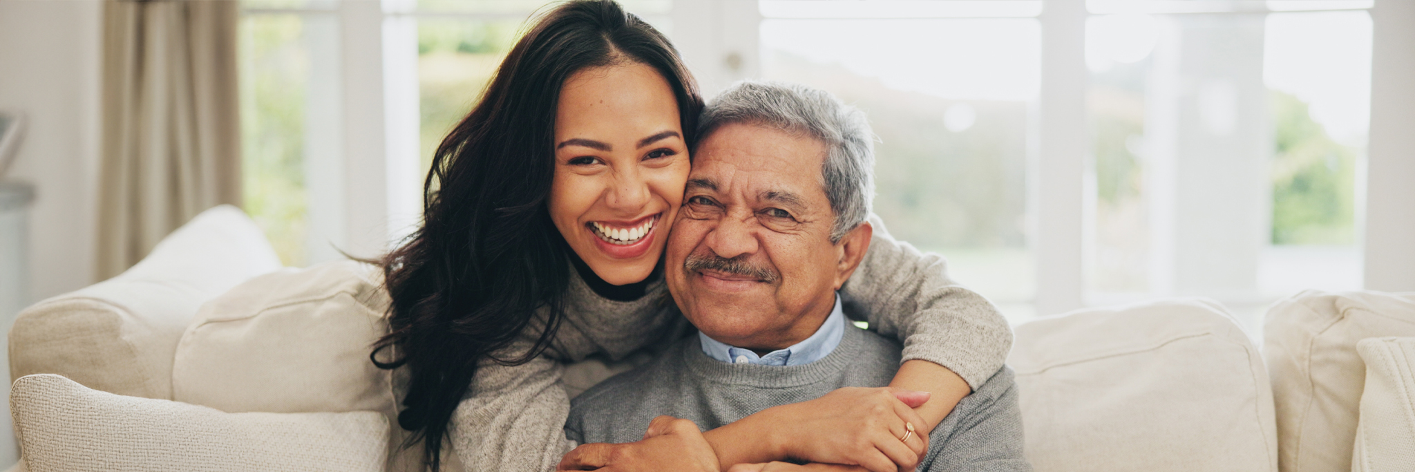 Portrait and Smile of Old Man With Daughter on Sofa in Living Room of Home for Bonding