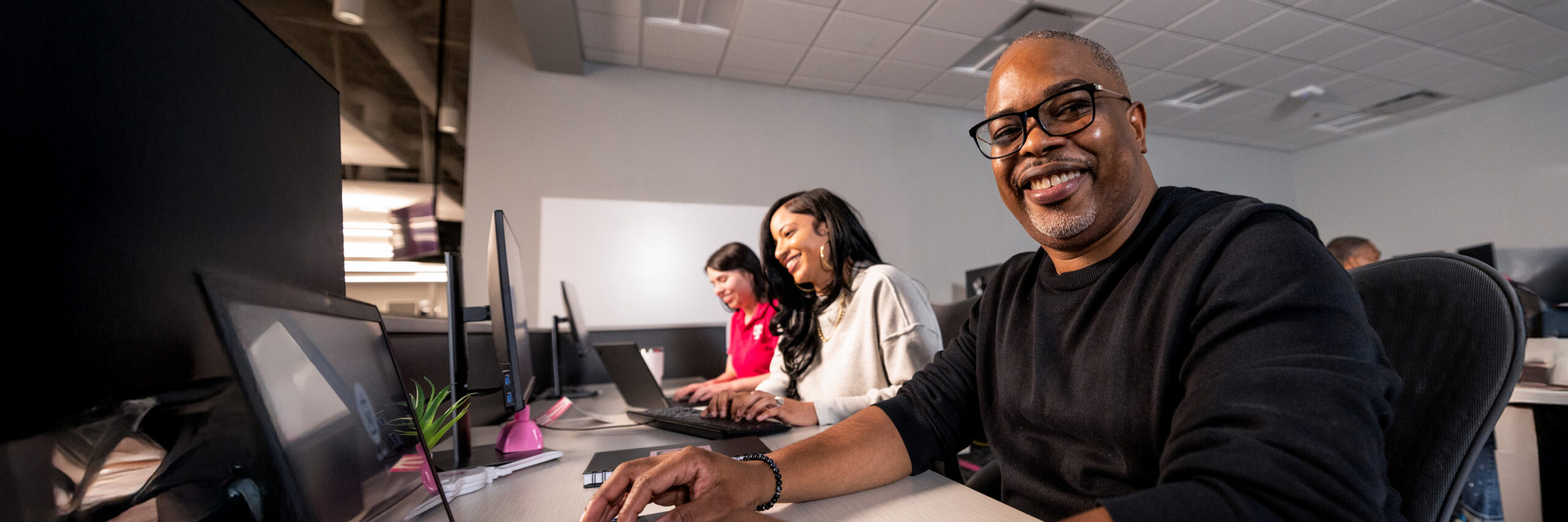 A group of T-Mobile employees working at desks in a modern office.